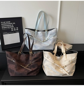 Detailed shot of large tote bags in canvas fabric with metal buckle leather straps