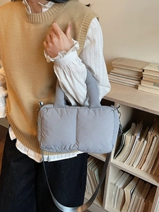 Grey quilted puffer shoulder bag with soft padded handles and adjustable fabric strap