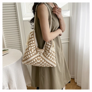 Detail of woven tote bag featuring geometric wave patterns and side tassel decoration