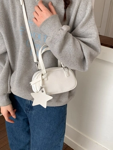 Mini white shell bowling bag with star charm and shoulder strap for crossbody wear