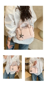Detailed view of pink Boston bag with silver star charm and adjustable shoulder strap