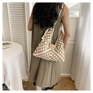Detail of bohemian hand-woven crochet tote bag with fringe tassels on model shoulder