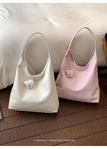 Detail of minimalist leather tote bags with logo lettering and decorative pouches