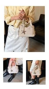 Close-up of cream white handbag with silver starfish pendant and smooth leather texture
