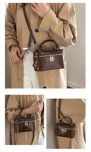 Sac à main carré vintage marron avec zips argentés et bandoulière porté par mannequin