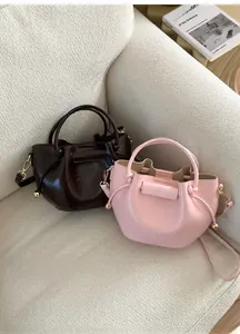 Detailansicht der weichen Leder-Eimertaschen in Braun und Rosa mit goldenen Metallperlen