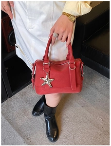 Close-up of red leather bowling bag with a stylish silver star-shaped metal pendant charm