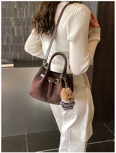 Detailaufnahme der braun karierten Mini-Beuteltasche mit Lederbesatz und Teddybär-Anhänger