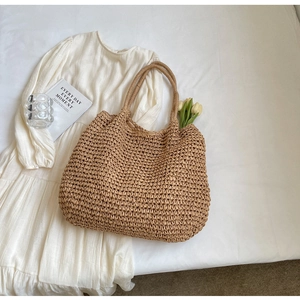 Dettaglio della trama della borsa in paglia intrecciata beige con decoro a tulipano