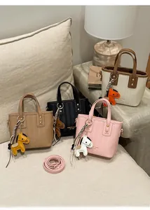 Detail of trendy bucket bags in four colors with leather horse charms and straps