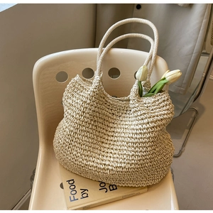 Dettaglio della borsa tote intrecciata crema con trama e tulipano su sedia minimalista