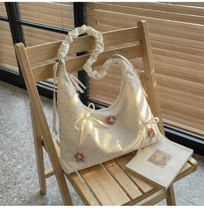 Close-up of canvas tote bag with red floral accents and ruffled shoulder strap detail