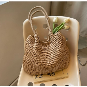 Dettaglio della borsa tote in paglia intrecciata a mano con doppi manici resistenti