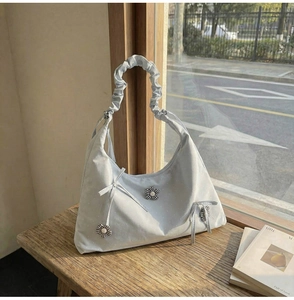 Detail of light blue floral tote bag with ribbon bow and ruffled cloud-style shoulder strap