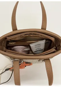 Interior view of small bucket bag showing storage for phone and cosmetics