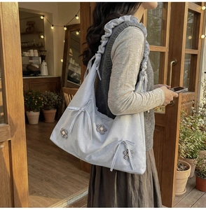 Close-up of light blue polka dot floral tote bag with bow detail and ruffled shoulder strap