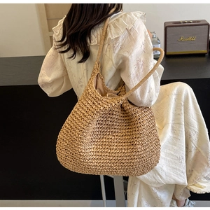 Dettaglio della borsa in paglia intrecciata a mano con fodera in tessuto e trama naturale