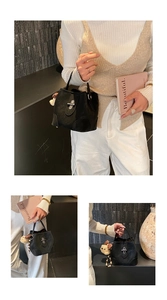 Detail of black bucket bag with silver turn-lock and cute bear pendant charm decoration