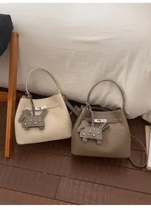 Detail of soft leather bucket bags featuring horse charm and metal turn-lock closures