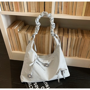 Close-up of light blue polka dot tote bag featuring 3D fabric flowers and bow detail
