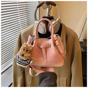 Details der rosa Tweed-Beuteltasche mit goldenen Beschlägen und Hunde-Anhänger