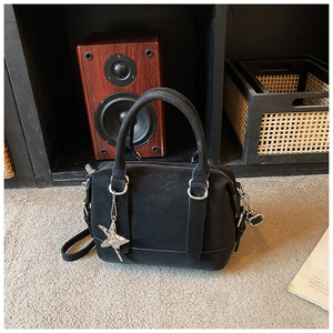 Close-up of a matte black bowling bag featuring silver hardware and a star-shaped pendant
