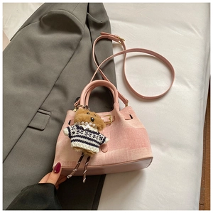 Detail der rosa Bucket-Bag mit verstellbarem Schultergurt und süßem Bärenanhänger