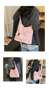 Detailed view of pink textured tote bag with cylindrical charm for daily commute