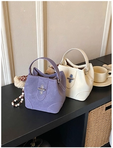 Detail view of stylish lavender and beige bucket bags with unique metal twist locks