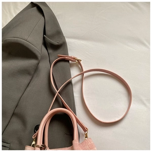 Detailansicht der rosa Denim-Beuteltasche mit Lederriemen und goldener Schnalle