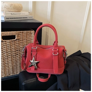 Detail of red bowling bag featuring silver star pendant and metallic zipper closure