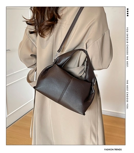 Dark brown lychee texture leather handbag styled with a beige trench coat on a model