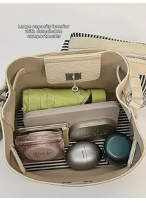 Detail view of large capacity beige bucket bag with striped lining and inner pouch