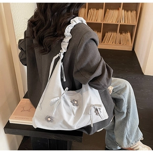 Detail of light blue hobo bag with 3D floral accents and ruffled shoulder strap