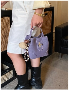 Detailed view of lavender bucket bag with lychee texture and silver twist lock buckle