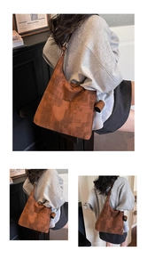 Detail view of large capacity crossbody bag with brown geometric jacquard pattern and tassel