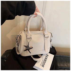 Detail of off-white leather bowling bag with silver hardware and starfish charm