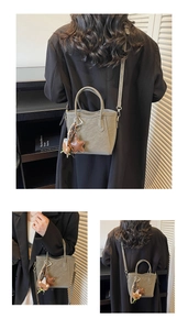 Olivgrüne Beuteltasche mit verstellbarem Riemen und süßem Bärenanhänger im Detail