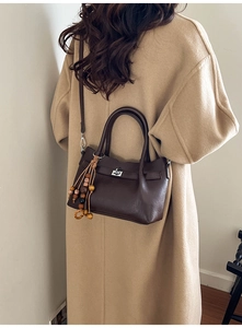 Detailed view of deep brown leather crossbody bag with ethnic style beaded tassel