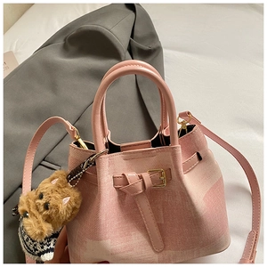 Detailansicht der rosa Beuteltasche mit strukturierter Oberfläche und Teddybär-Anhänger