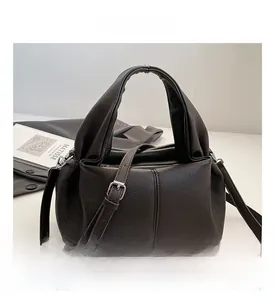 Macro detail of dark brown lychee grain leather handbag with silver zipper and strap