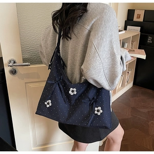 Detail of navy polka dot tote bag featuring 3D daisy flowers and a decorative bow tie