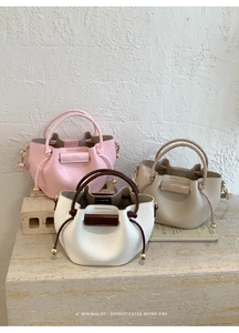Detailansicht der Kordelzug-Beuteltaschen in Rosa, Weiß und Beige mit Goldbeschlägen
