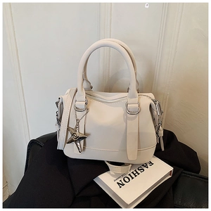 Detail of off-white bowling bag with silver star charm and detachable leather strap