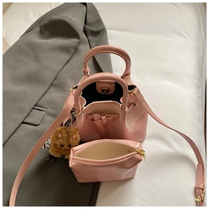 Rosa Eimertasche mit Innentasche und Teddybärenanhänger auf weißem Laken
