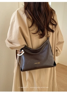 Detail of vintage brown leather tote bag with gold logo and horse-shaped pendant
