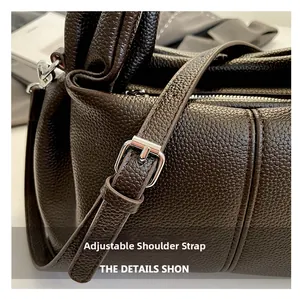 Close-up of dark brown lychee leather texture with adjustable silver buckle strap