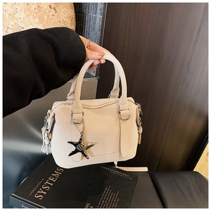 Detail of off-white bowling bag with silver rings, tassel charm and star pendant decoration