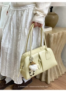 Detail of retro cream leather handbag with front pocket and plush charm accessory