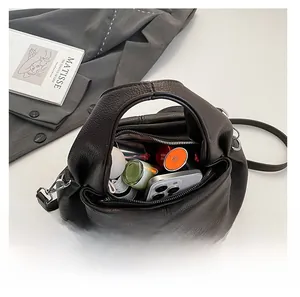 Interior view showing large capacity of the brown dumpling bag with daily essentials